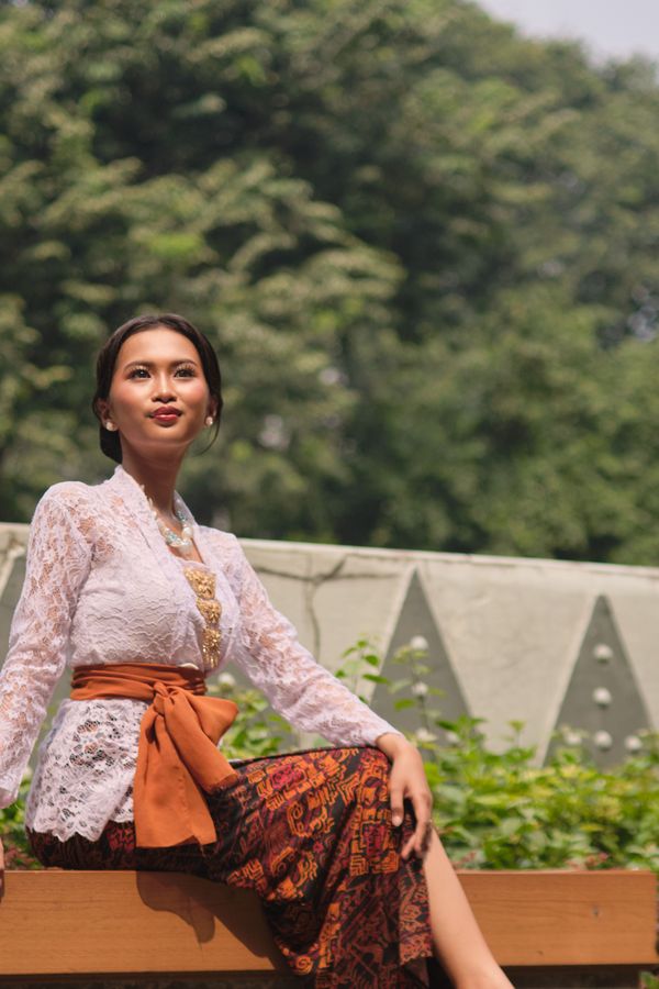 Perempuan mengenakan kebaya modern dengan rok batik parang